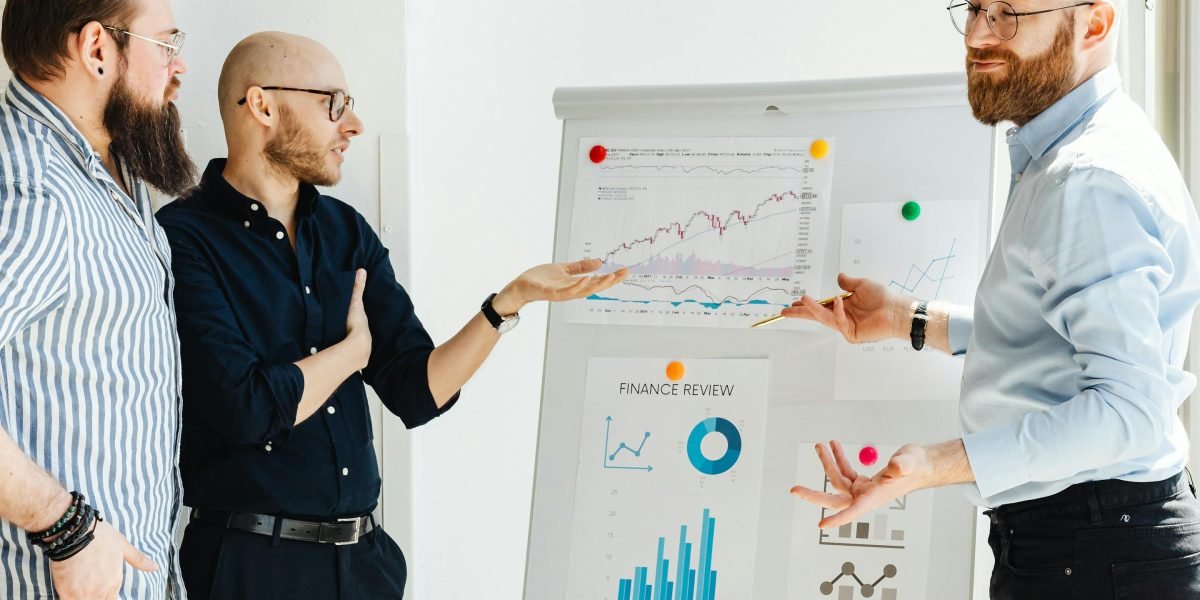 A team discussing market trends using a whiteboard, illustrating the analytical aspect of real estate expertise.