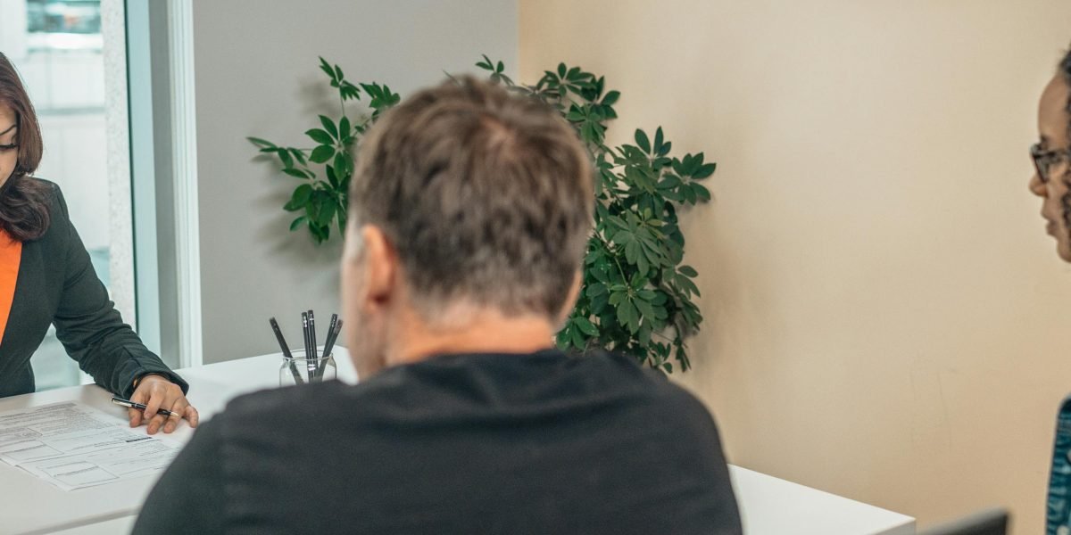 A professional real estate agent providing personalized consultation to a client, outlining comprehensive property services.
