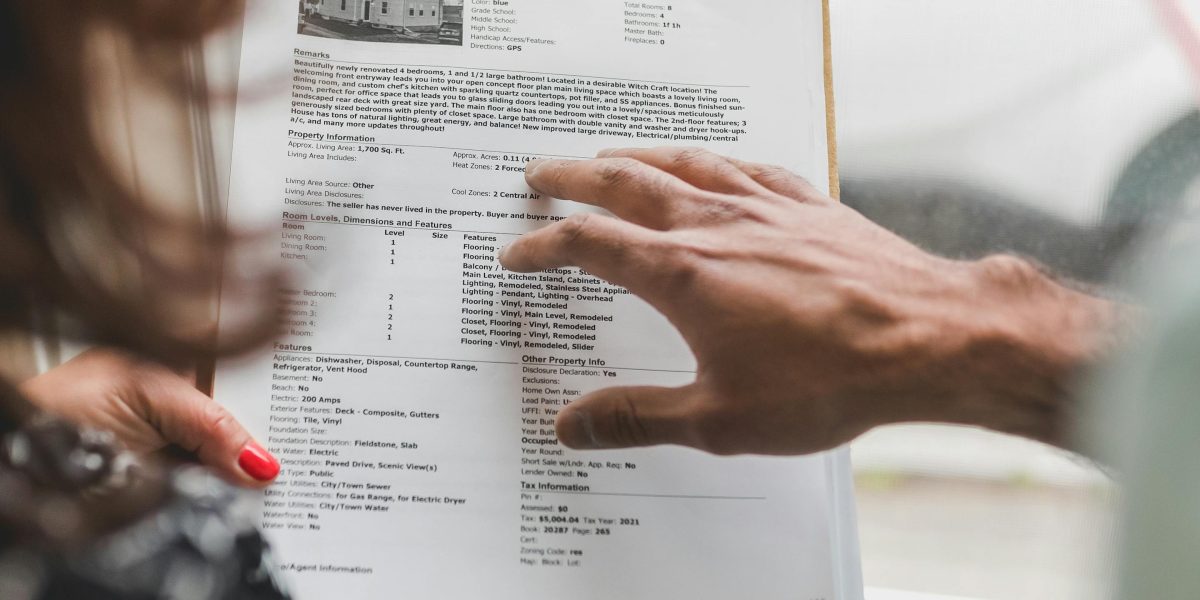 A real estate professional guiding a client through important property transaction documents.