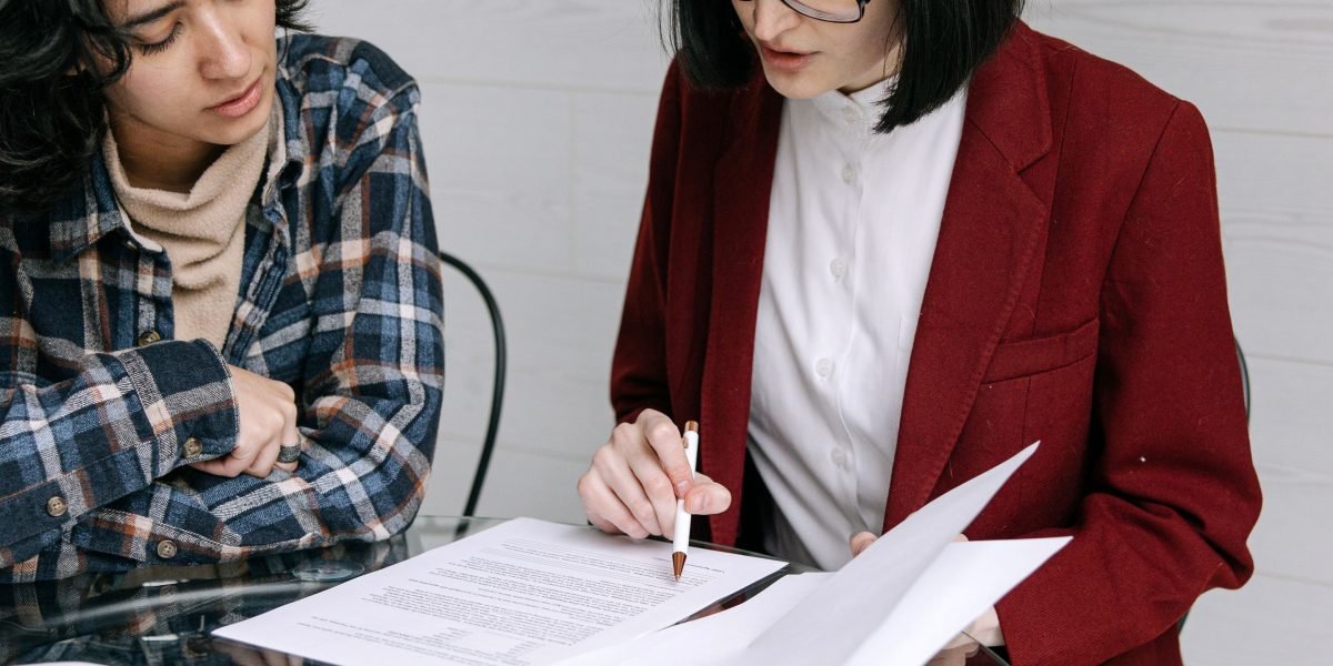 Professionals verifying documents, symbolizing the crucial step of checking a real estate agent's credentials.