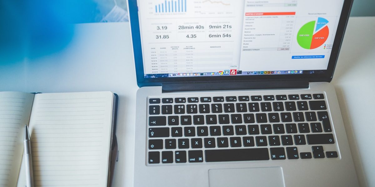 An individual meticulously reviewing market reports and financial documents to understand real estate trends.