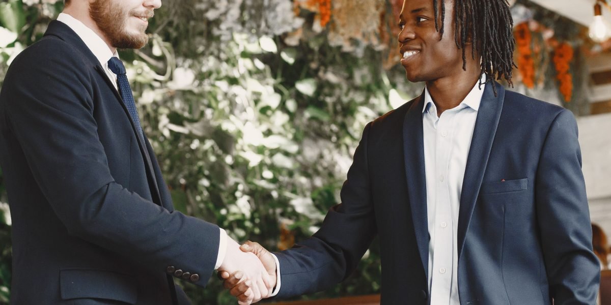 Professionals shaking hands after successfully closing a high-value real estate deal.