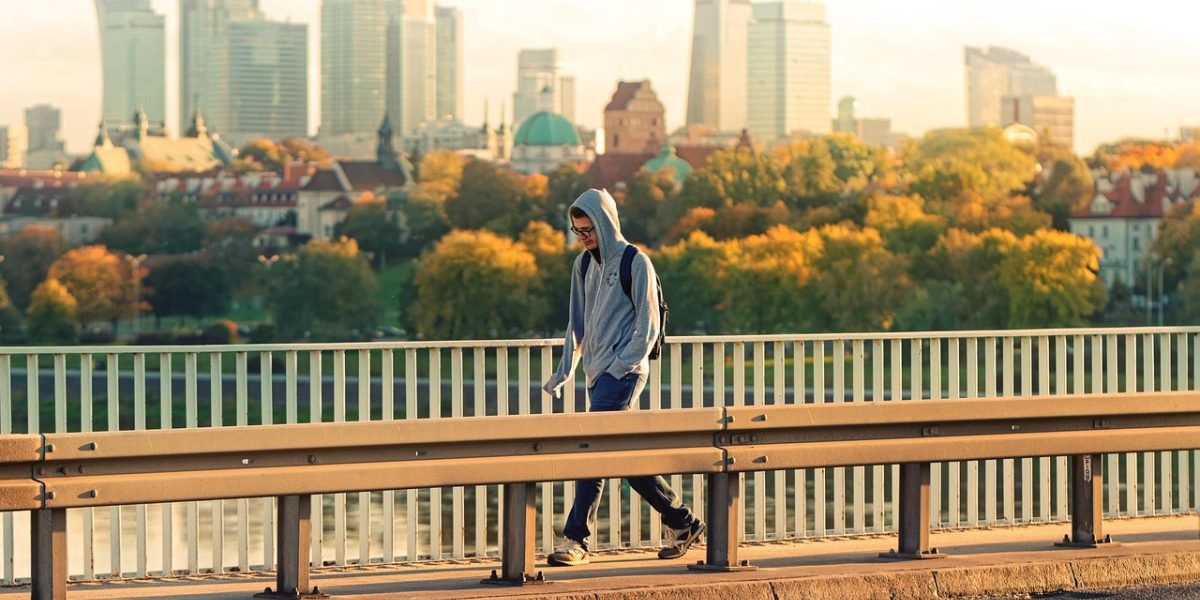 A confident person looks at a vibrant city skyline, symbolizing a positive future outlook for business and investment.
