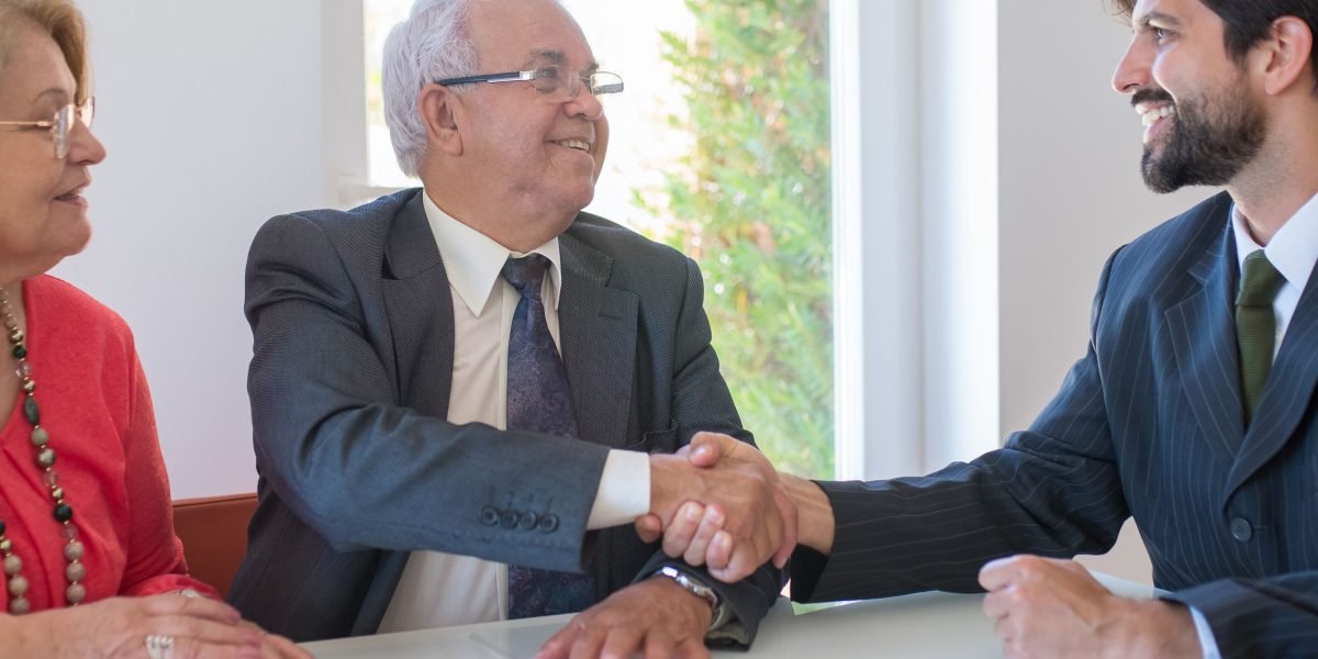 Two business professionals shaking hands, symbolizing trust and a successful partnership in the process of selecting a real estate firm.