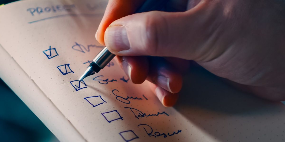 A person carefully reviewing a checklist, representing the crucial due diligence process for selecting a real estate advisor.