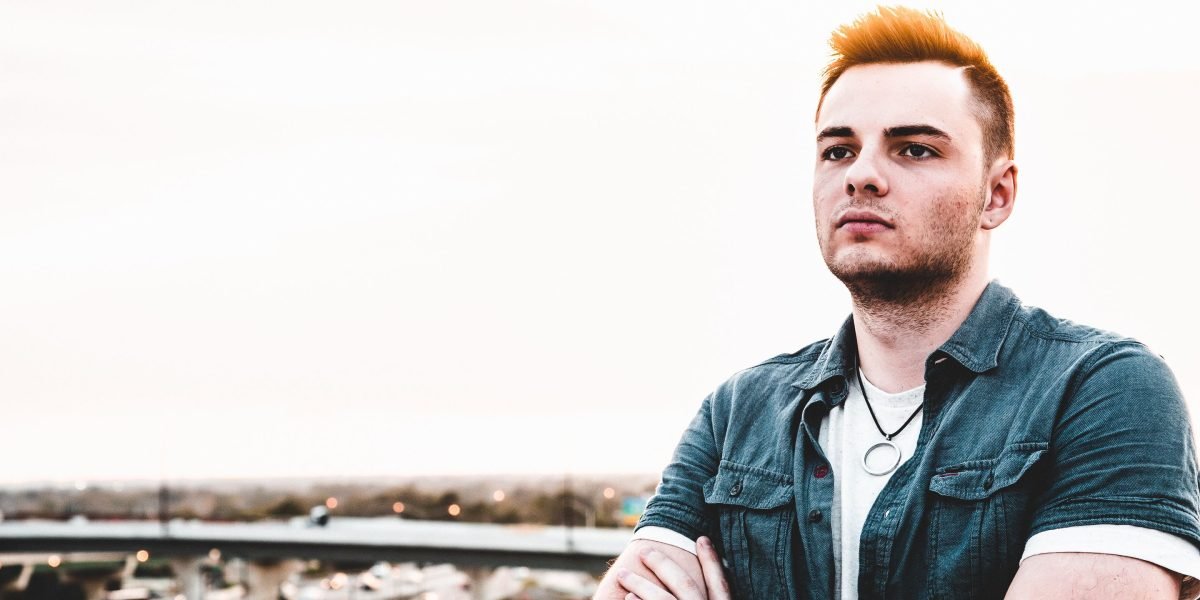 A confident individual looks out over a vibrant city skyline, symbolizing a strong future investment.