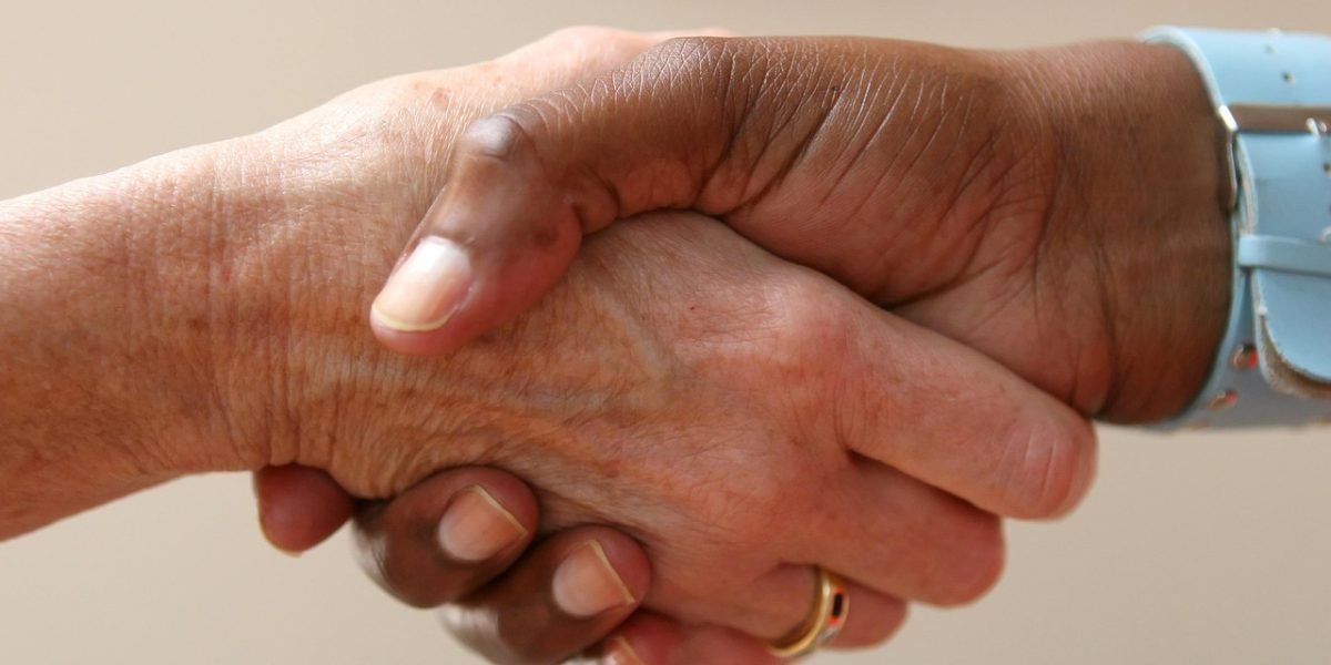 Two professionals shaking hands, symbolizing a successful negotiation or property transaction completion.