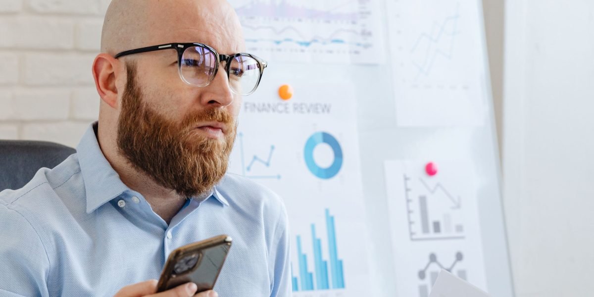A person thoughtfully considering large-scale investment options, reflecting the importance of brand in luxury real estate decisions.
