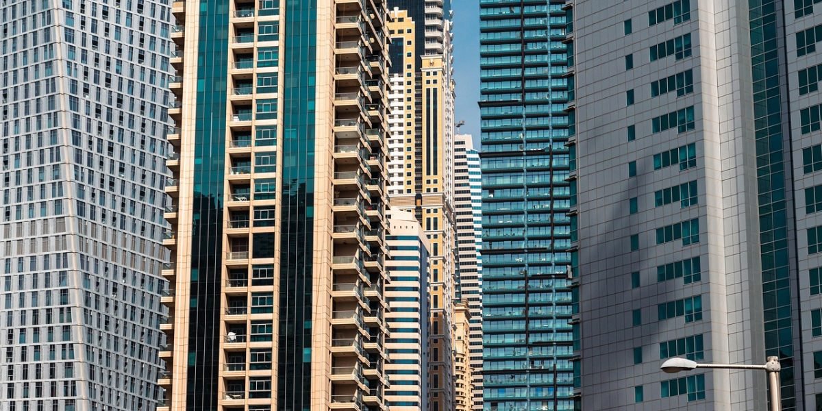 An individual carefully reviewing documents and details to evaluate potential luxury properties for purchase.