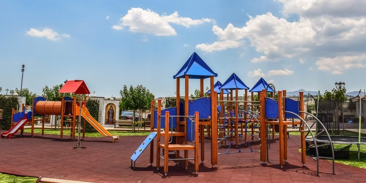 A family enjoys leisure time in a modern, green community park, reflecting a desirable lifestyle.